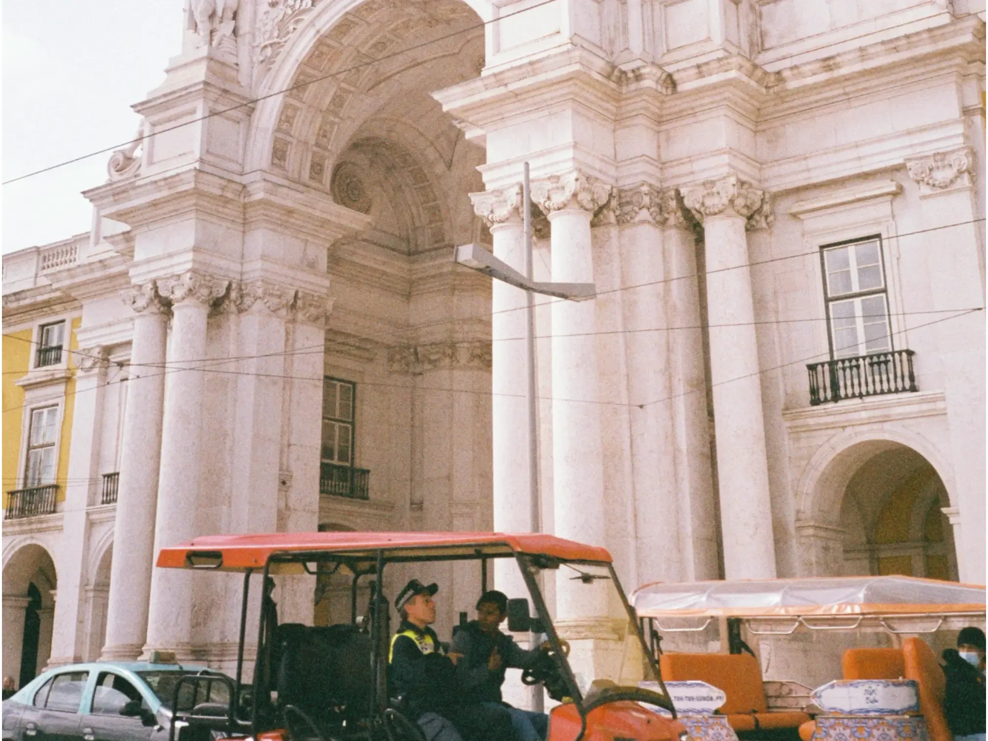 Grainy texture over a street scene with an ornate building and a tuk-tuk, highlighting the effects of high ISO and exemplifying challenges of how to make photos not blurry.