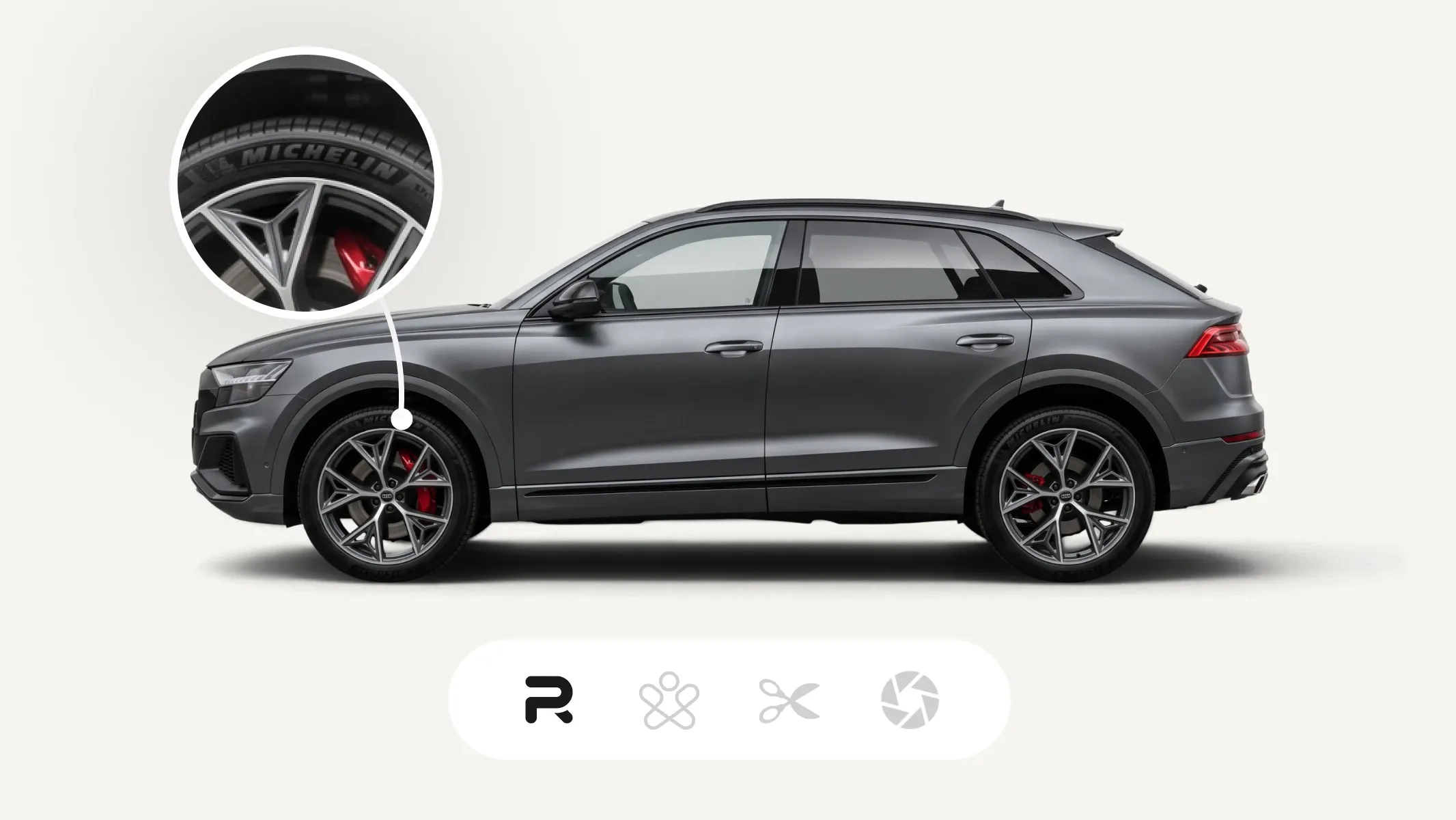 A sleek, gray SUV with a close-up of its wheel, showing a Michelin tire and red brake caliper. The vehicle has tinted windows and modern styling.
