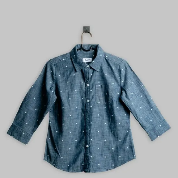 Seller photo of a denim shirt on a hanger, flat grey light, before relighting