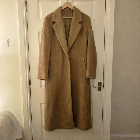 The same coat relit by the Photoroom API: bright, even light